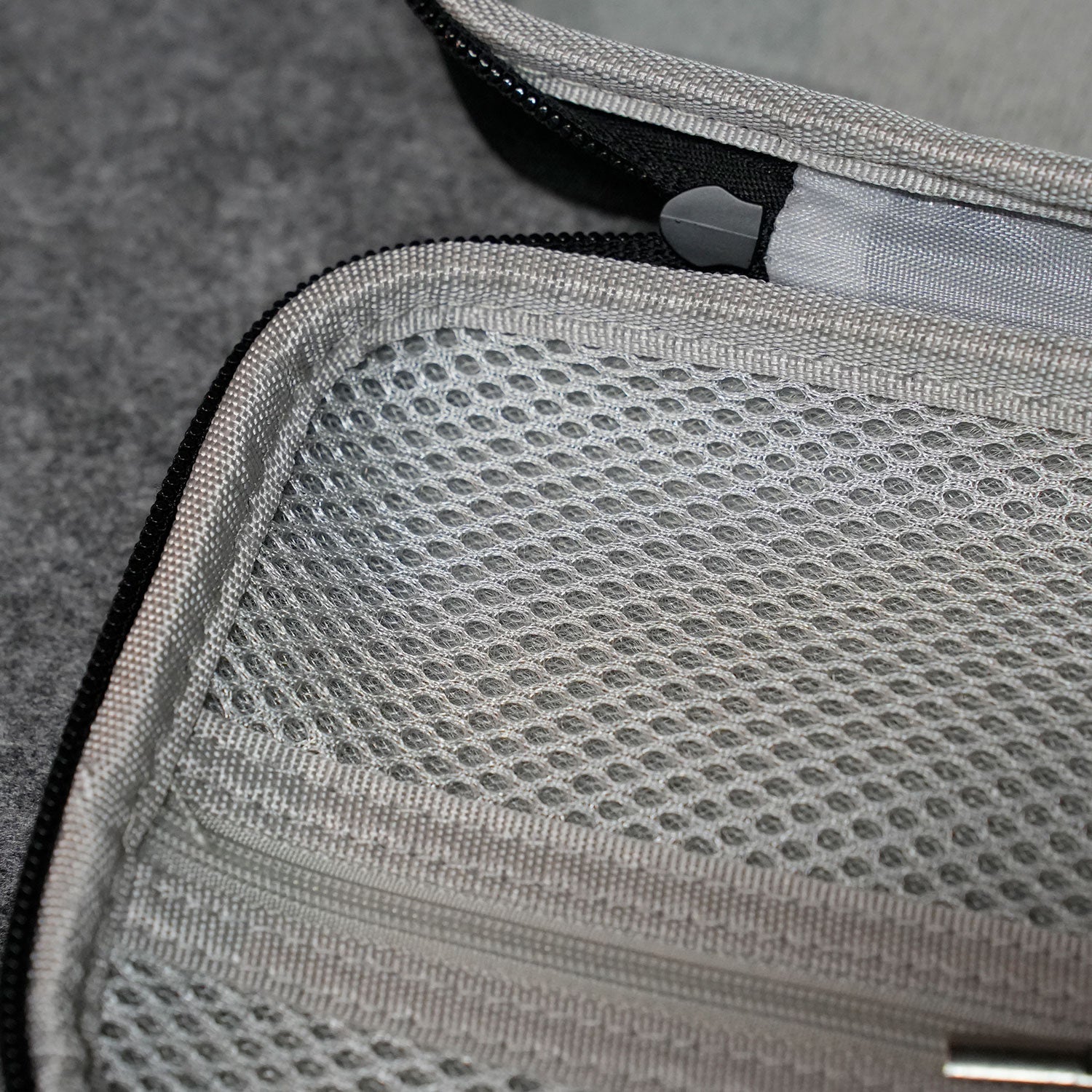 Close-up of a Akko Keyboard Carrying Case with a zipper on a textured surface